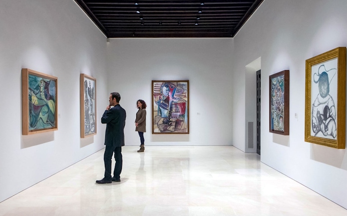 Visitors viewing paintings at Picasso Museum in Malaga.
