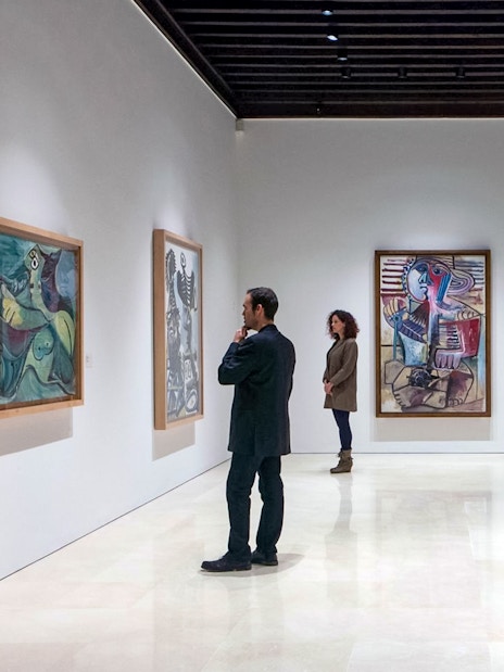 Visitors viewing paintings at Picasso Museum in Malaga.