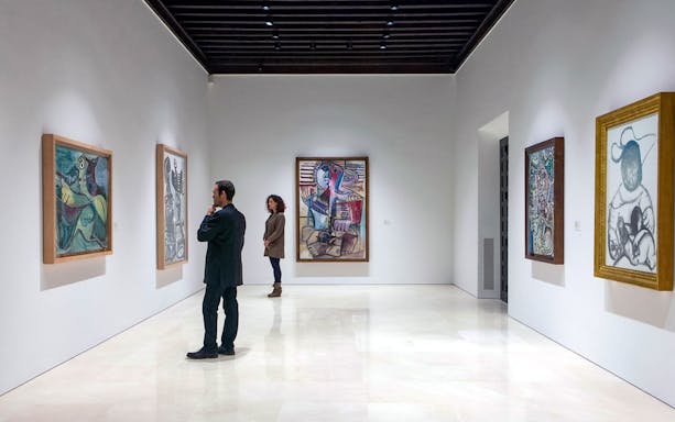 Visitors viewing paintings at Picasso Museum in Malaga.