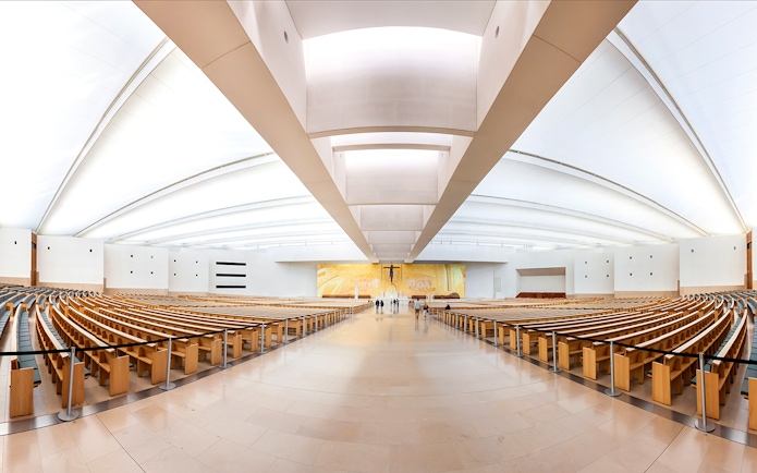Interior of the Sanctuary of Fátima with rows of wooden pews, part of the Fátima & Coimbra tour.