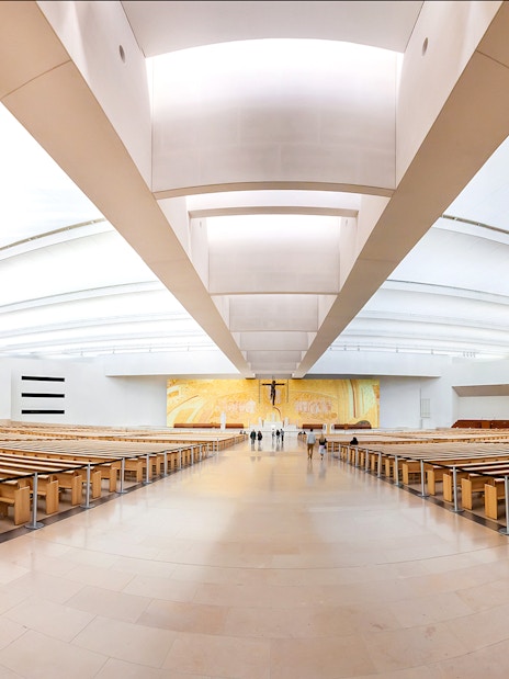 Interior of the Sanctuary of Fátima with rows of wooden pews, part of the Fátima & Coimbra tour.
