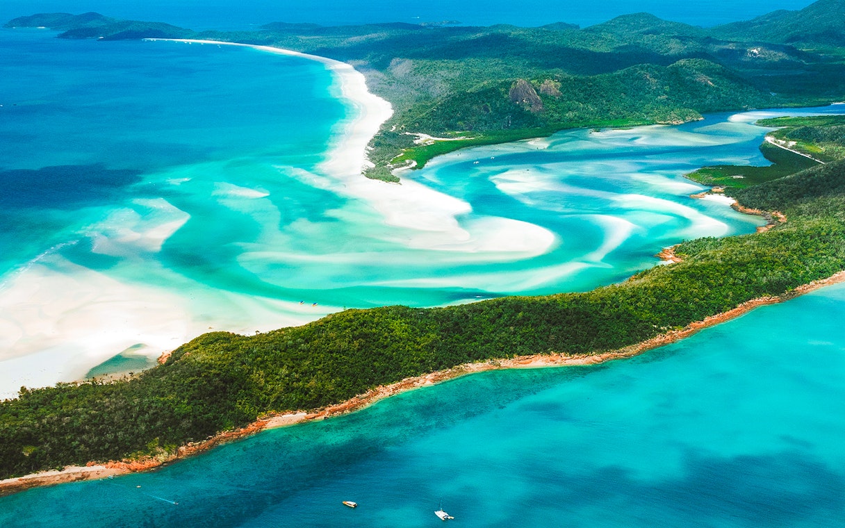 Aerial view of Whitsundays' turquoise waters and white sandy beaches.