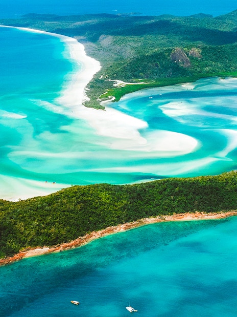 Aerial view of Whitsundays' turquoise waters and white sandy beaches.