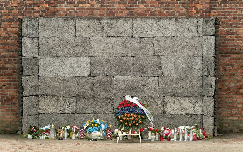 Memorial wall with flowers and candles at Auschwitz-Birkenau Concentration Camp.