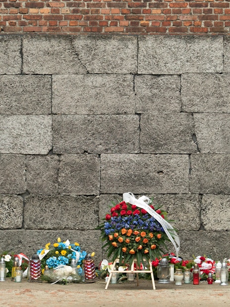 Memorial wall with flowers and candles at Auschwitz-Birkenau Concentration Camp.