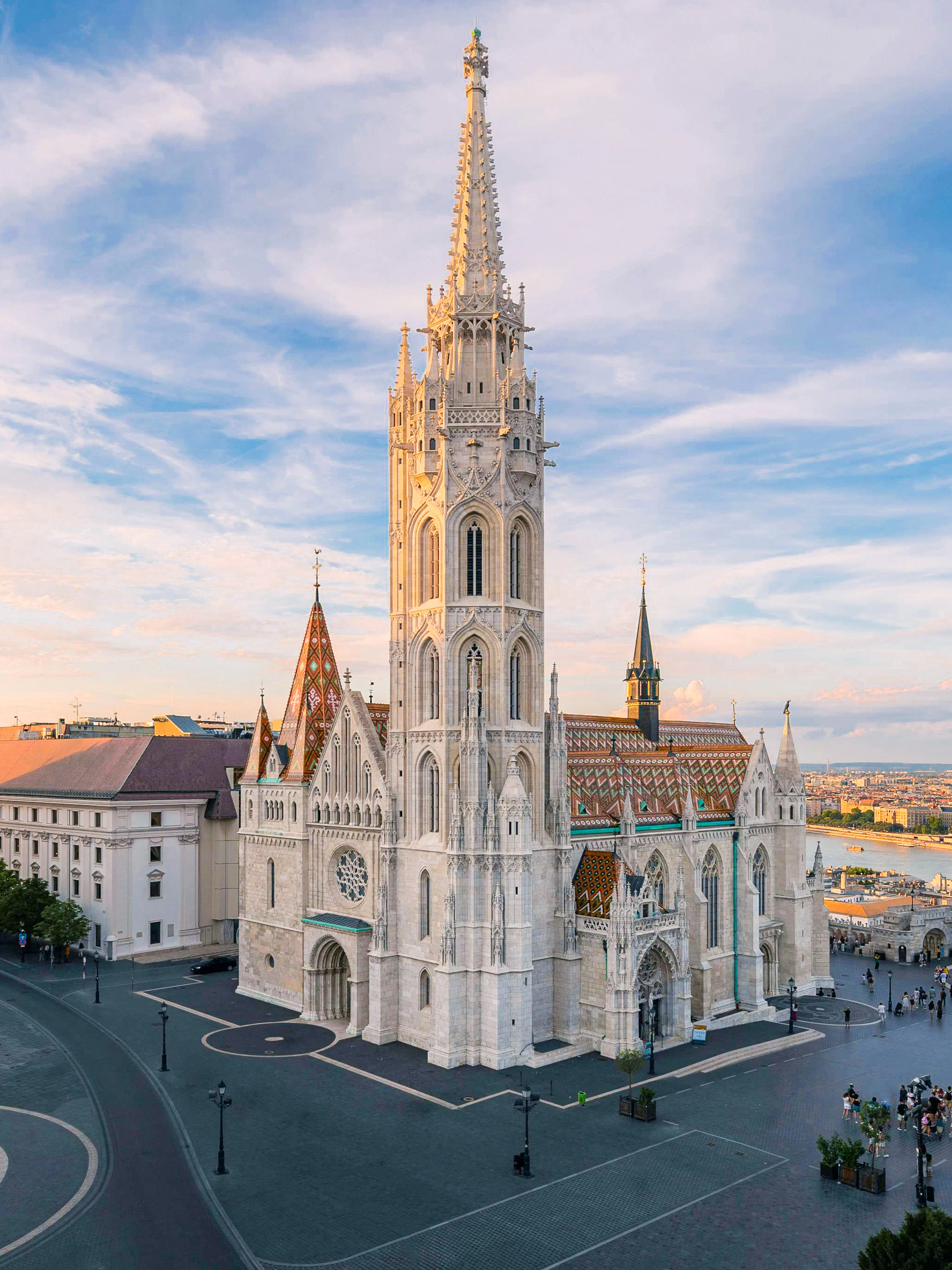 Matthias Church and Fisherman's Bastion in Budapest at sunset, overlooking the Danube River.