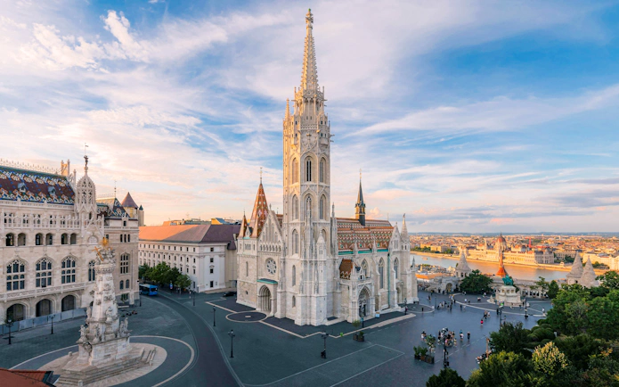 Matthias Church and Fisherman's Bastion in Budapest at sunset, overlooking the Danube River.