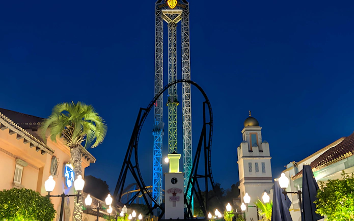 Parque Warner tower and roller coaster illuminated at night.