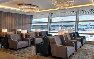 Plaza Premium Lounge seating area with airport view at Kuala Lumpur International Airport.
