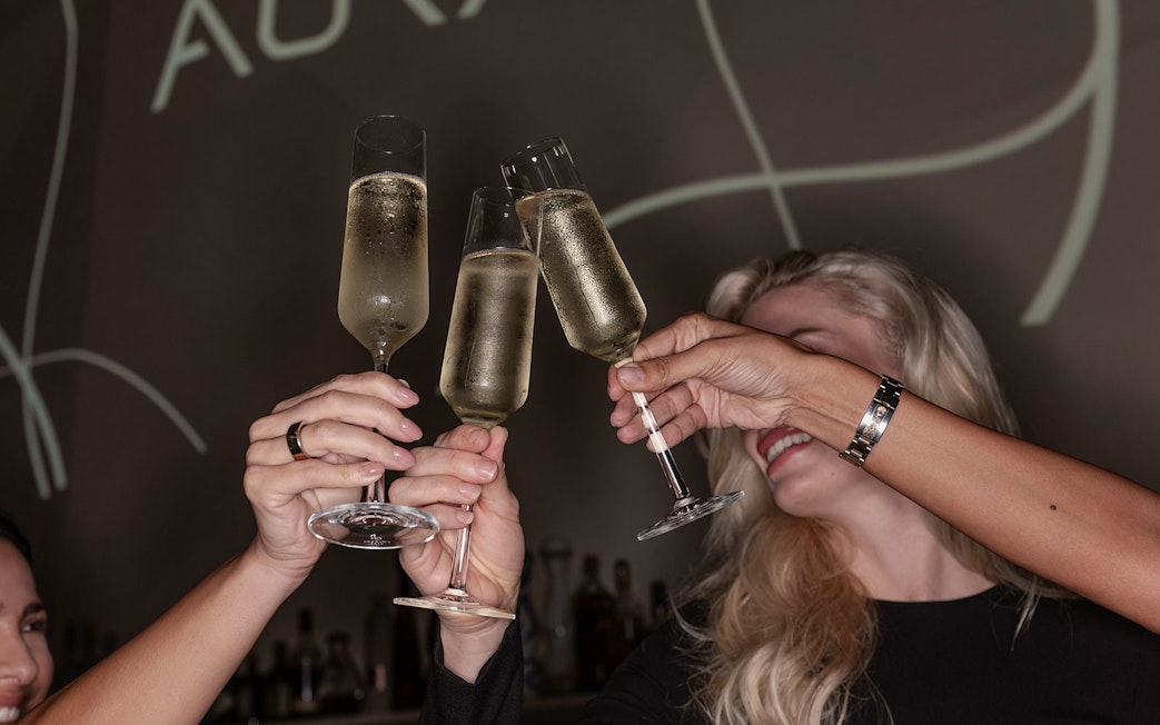 Guests toasting with champagne at Aura Sky Pool.