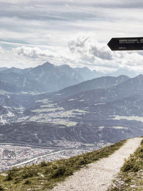 Nordkettenbahn mountain view with signpost on hiking trail, Innsbruck, Austria.