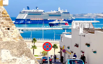 Cruise ship docked at Tangier port with view of Medina street and Kasbah wall.