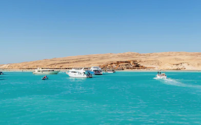 Boats with tourists on azure waters near Orange Bay Beach, Hurghada, Egypt.
