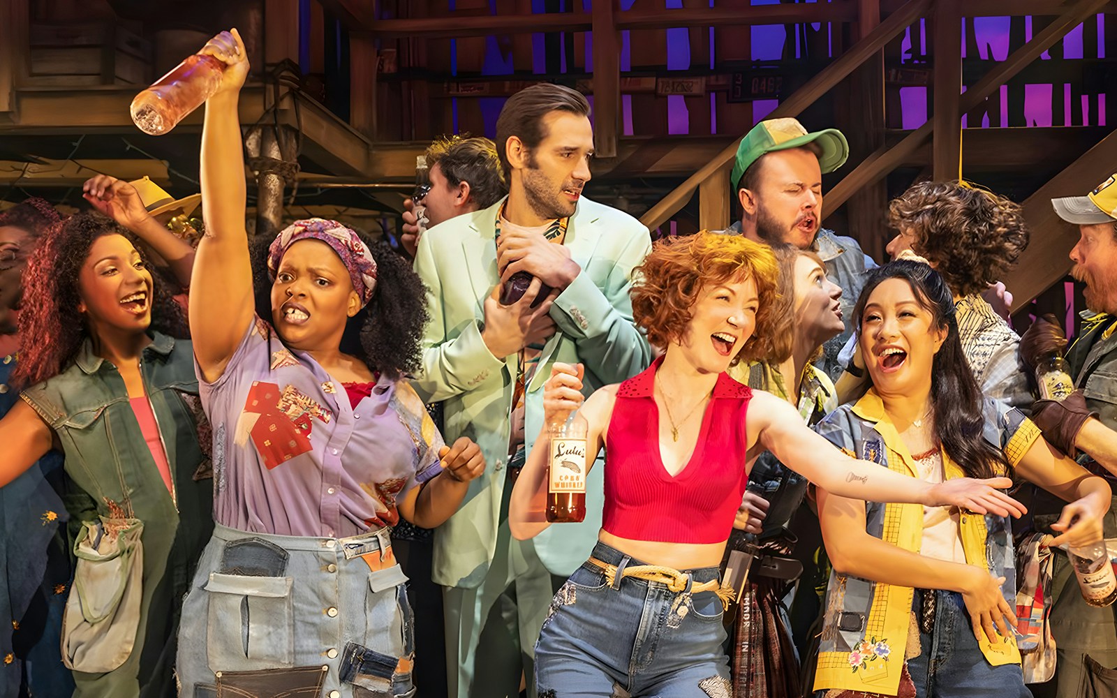 Group of performers celebrating on stage during the musical "Shucked.