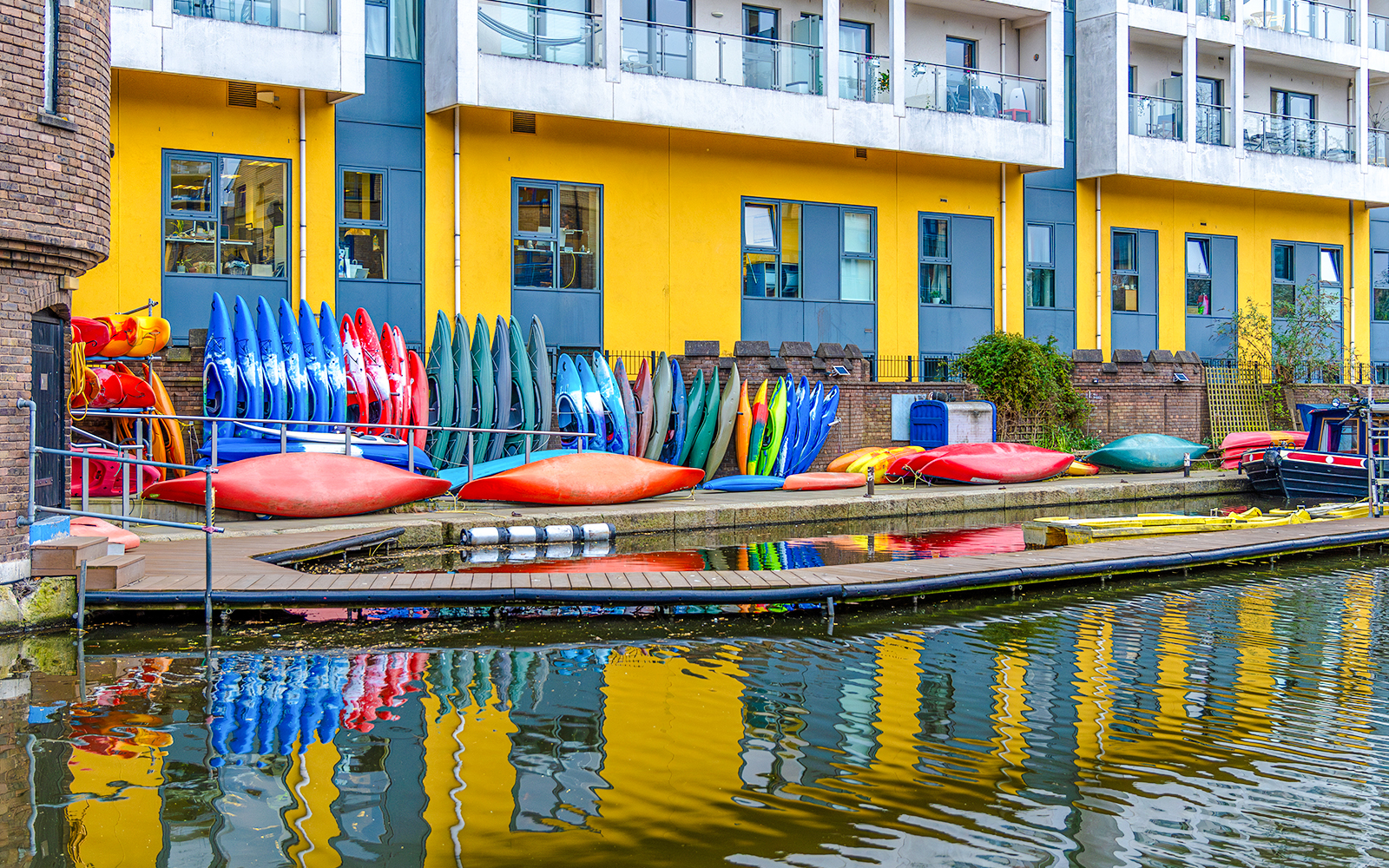 Kayaks stacked by Regent's Canal in London, ready for a kayaking tour.