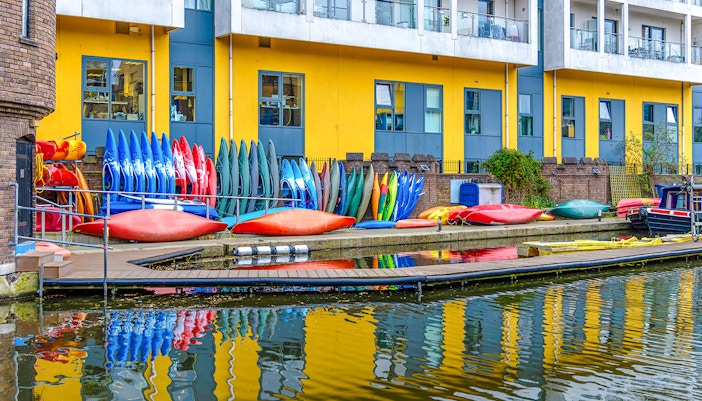 Kayaks stacked by Regent's Canal in London, ready for a kayaking tour.