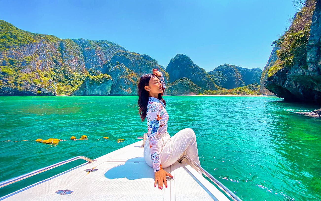 Woman enjoying a boat ride in Krabi with view of Phi Phi Islands.