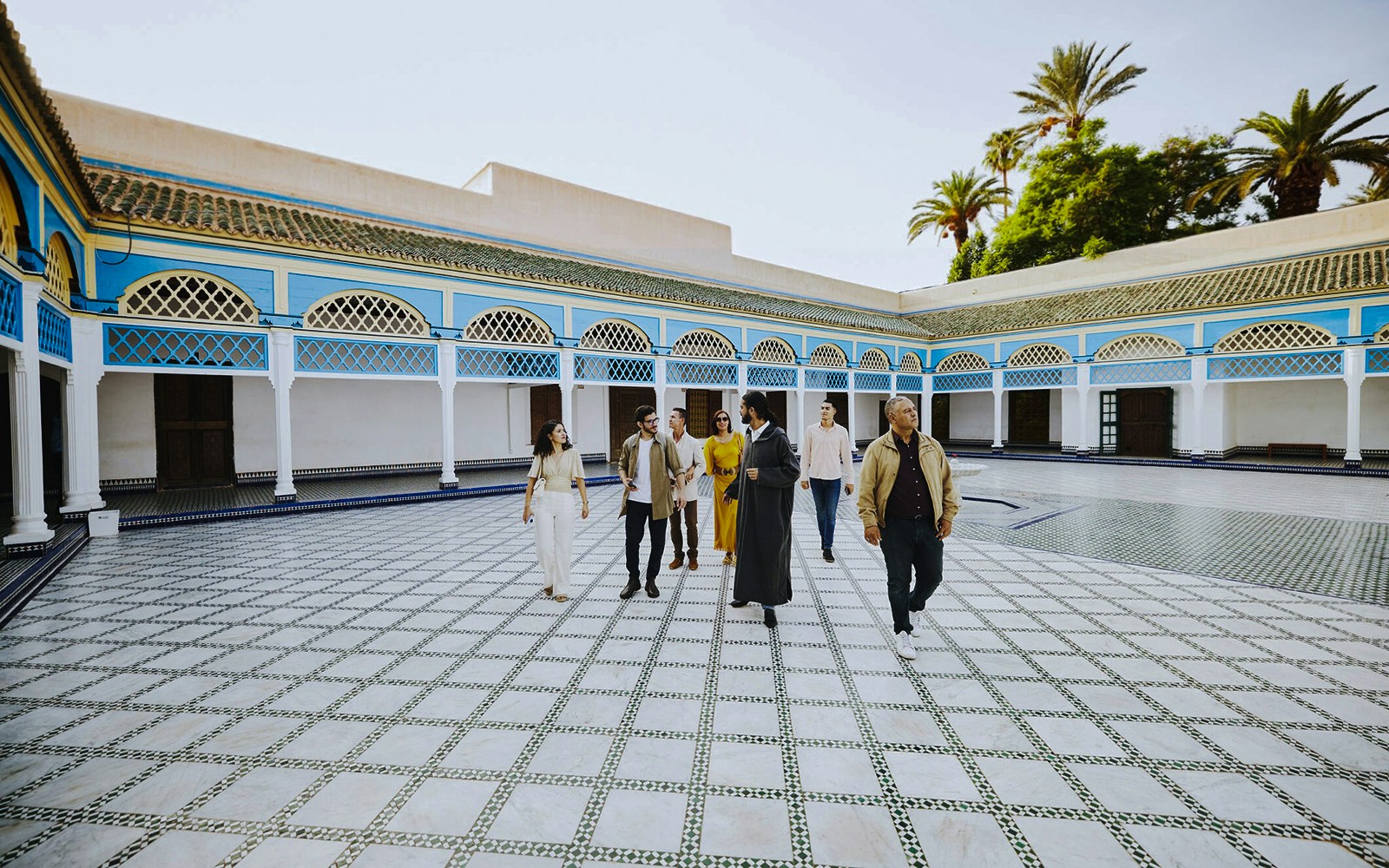 Group tour exploring the courtyard of Bahia Palace, Marrakech, Morocco.