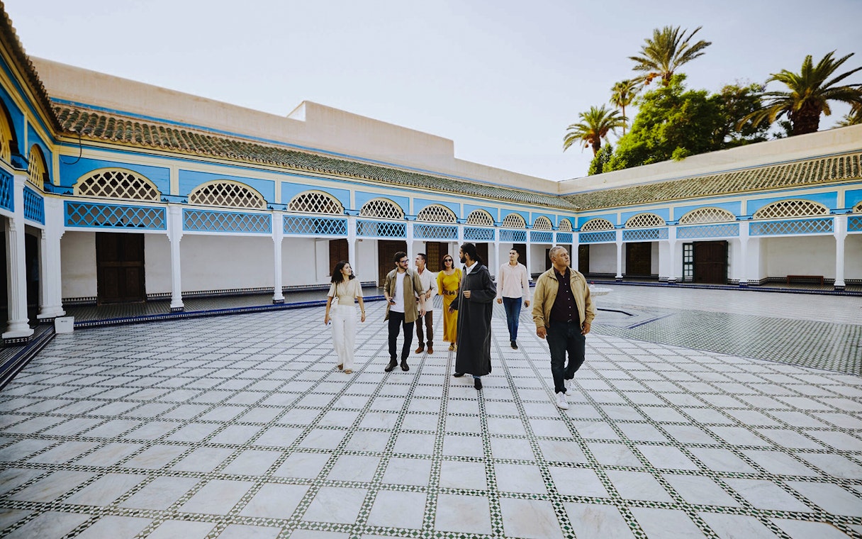 Group tour exploring the courtyard of Bahia Palace, Marrakech, Morocco.