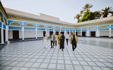 Group tour exploring the courtyard of Bahia Palace, Marrakech, Morocco.
