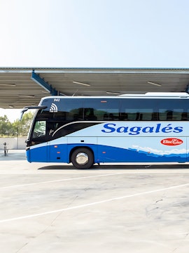 Blue and white Sagales bus at Girona Airport transfer station.