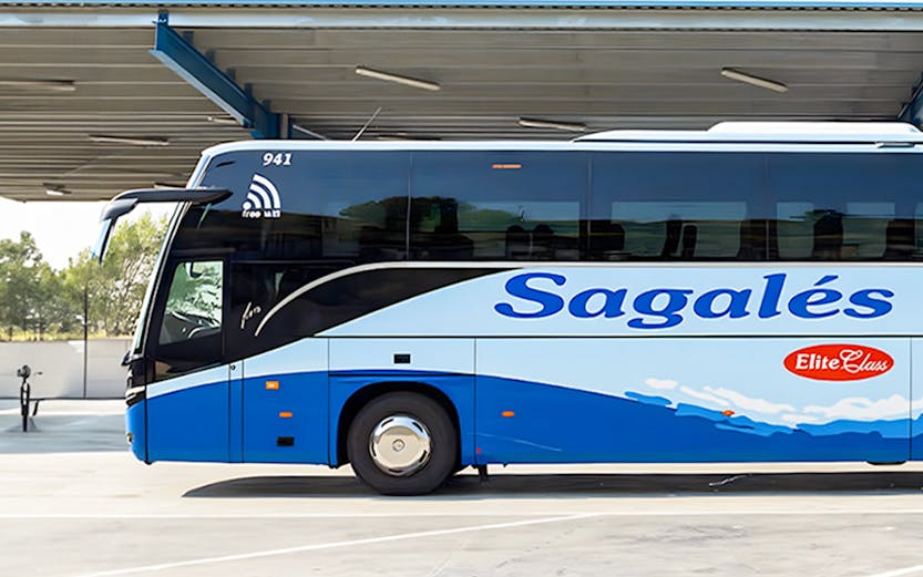 Blue and white Sagales bus at Girona Airport transfer station.