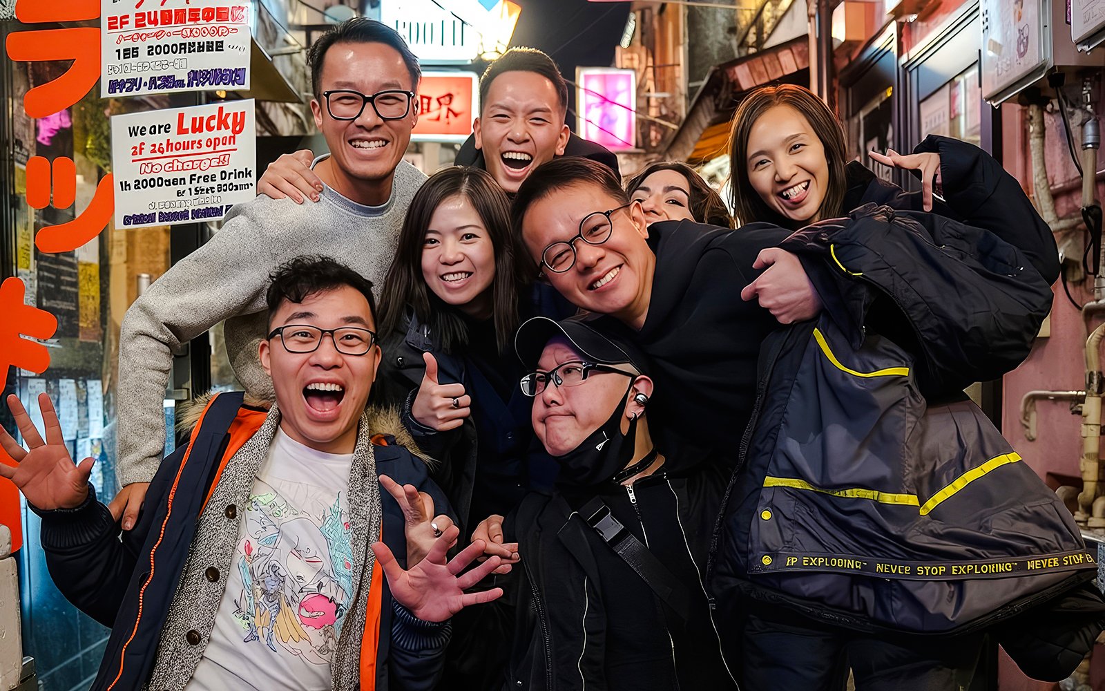 Tourists smiling and posing in a lively alley during the Shinjuku Local Bar & Izakaya Crawl in Tokyo.