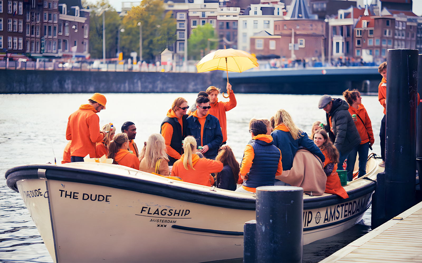 People in orange clothing on a boat during Amsterdam King's Day party cruise.
