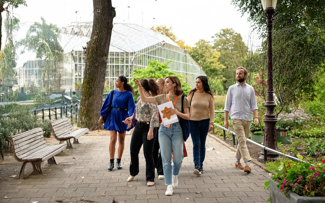 Group on Anne Frank Story and World War II walking tour in a park setting.