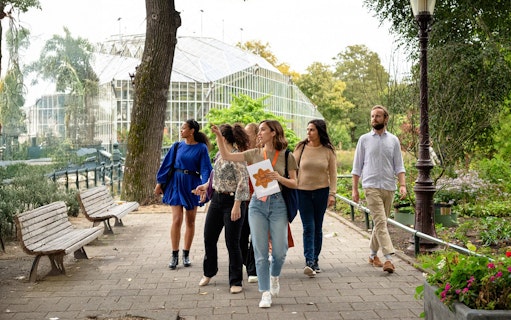 Group on Anne Frank Story and World War II walking tour in a park setting.