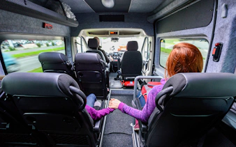 Passengers seated inside a minivan during an Athens airport transfer.