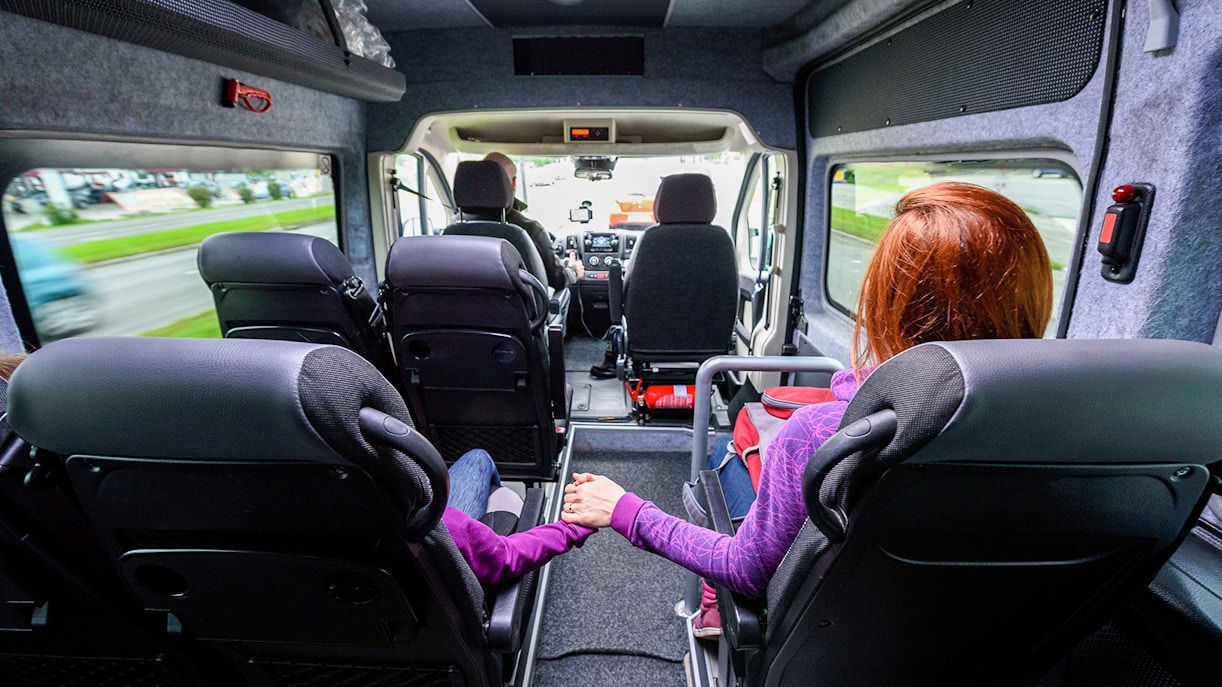 Passengers seated inside a minivan during an Athens airport transfer.