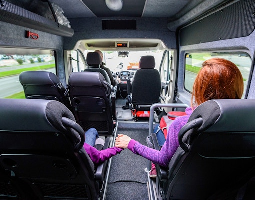 Passengers seated inside a minivan during an Athens airport transfer.