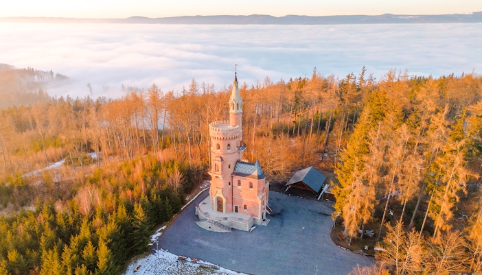 Goethe’s Lookout Tower surrounded by forest and mist in Prague.