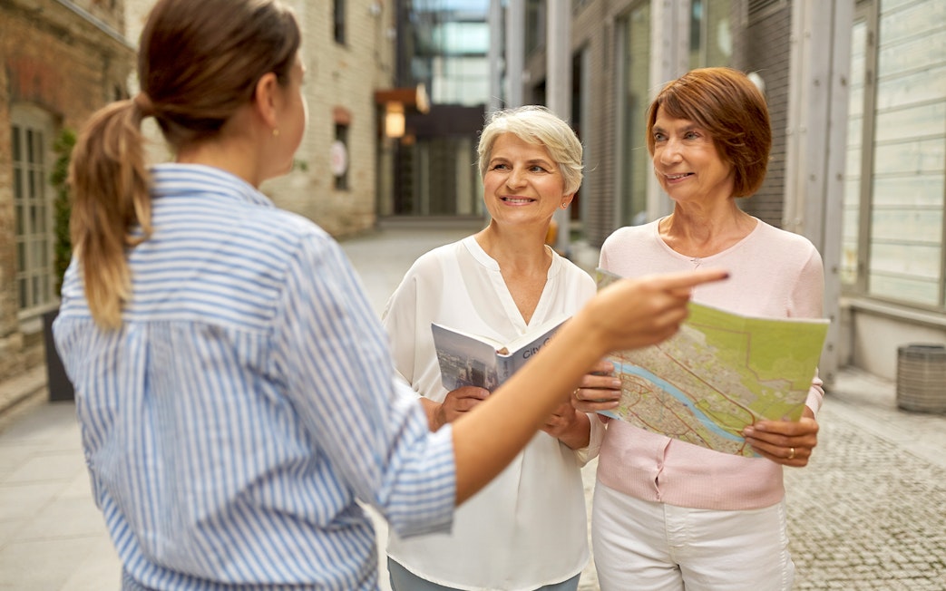 Tourists with guidebook and map discussing SkiptheLine tickets at Pompeii.