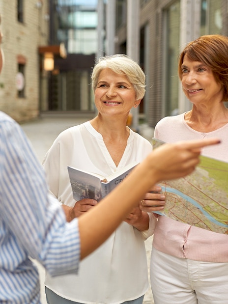 Tourists with guidebook and map discussing SkiptheLine tickets at Pompeii.