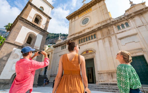 Tourists exploring a historic church in Positano during a guided tour from Sorrento.