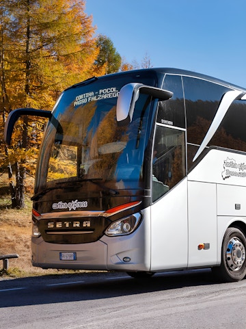 Shuttle bus on route from Marco Polo Airport through scenic autumn landscape.