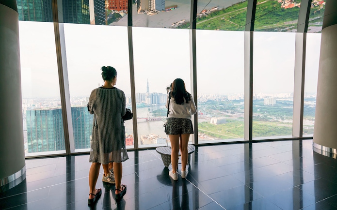 Visitors enjoying the panoramic view from a sky deck in downtown Ho Chi Minh City, Vietnam.