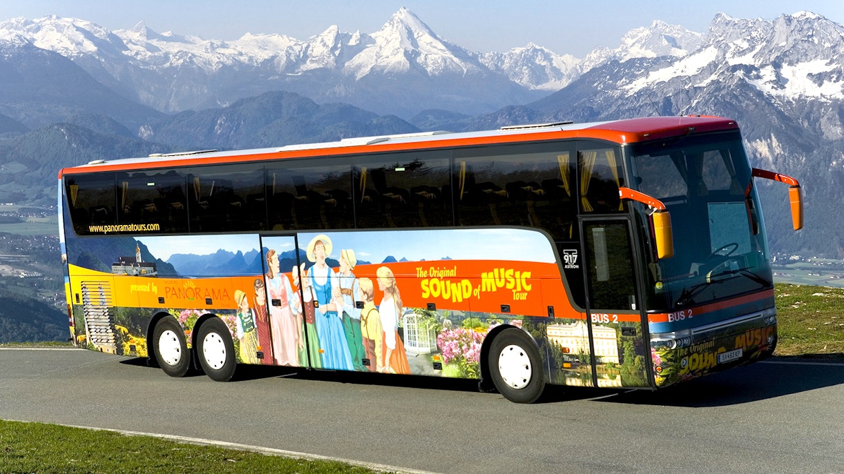 Original Sound of Music tour bus with mountain backdrop in Salzburg, Austria.