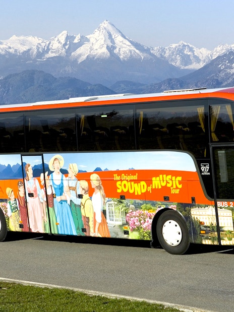Original Sound of Music tour bus with mountain backdrop in Salzburg, Austria.