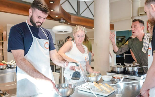 Participants in a Florence cooking class making pasta and dessert.
