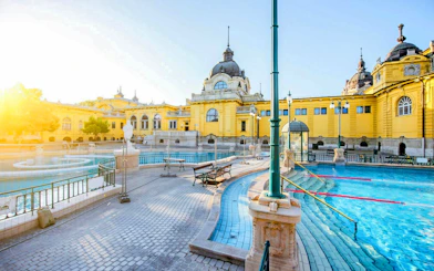 Széchenyi Spa outdoor pool with historic yellow building in Budapest.