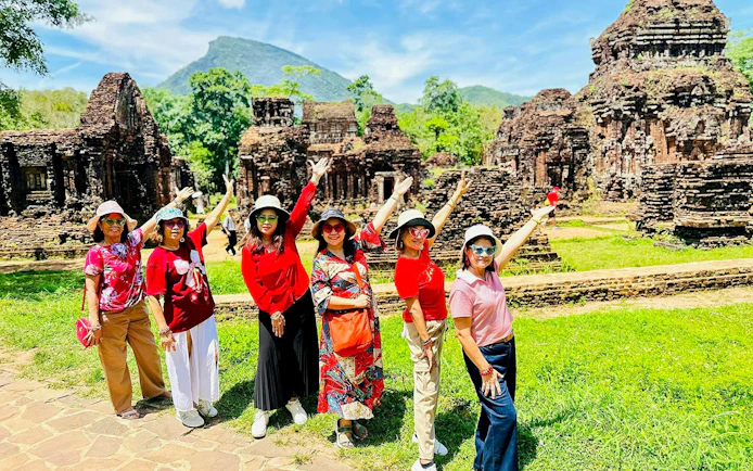 Group of women posing at My Son Sanctuary Hindu temple ruins in Vietnam.