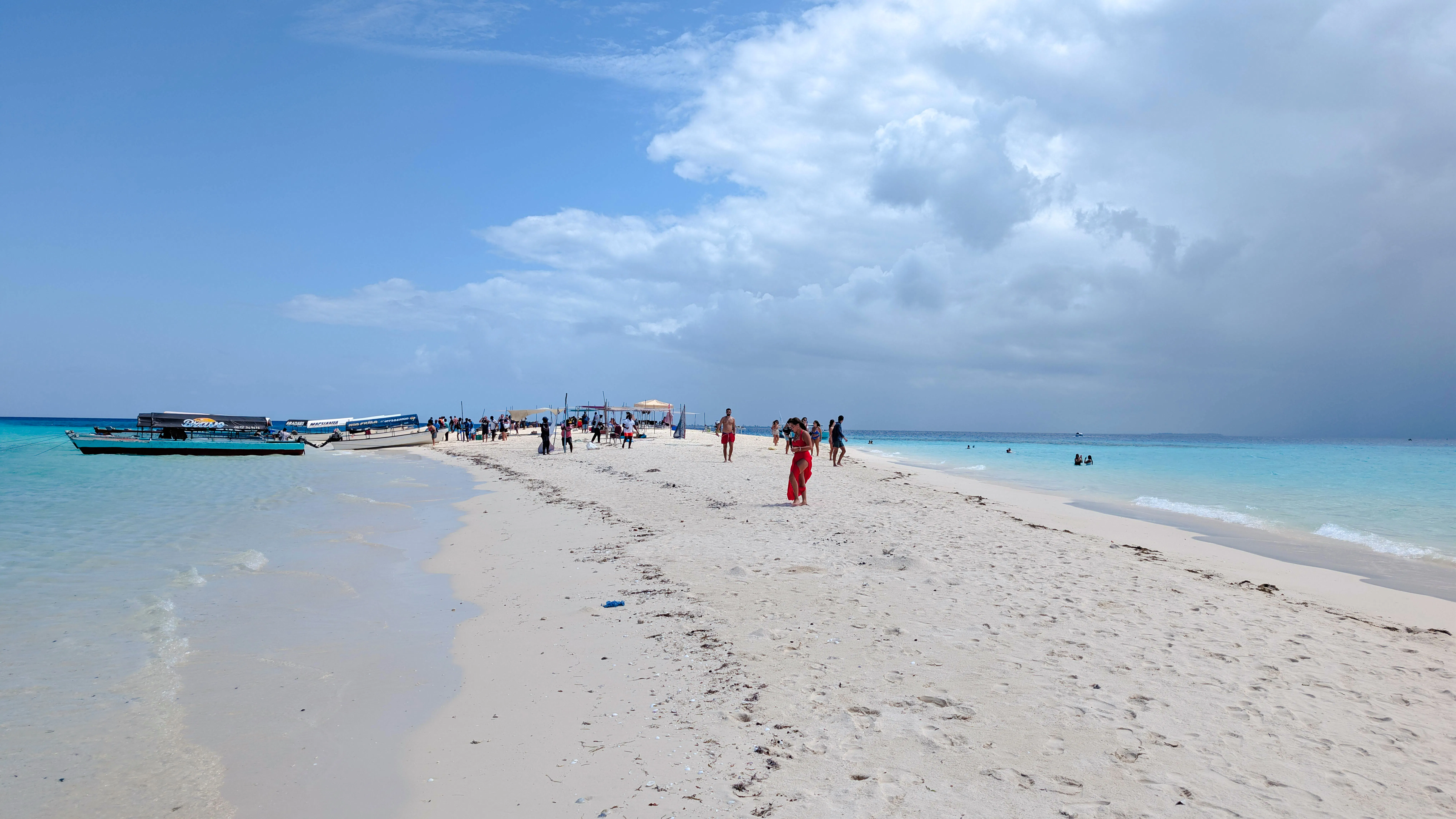 Sandbank with visitors and boats, Zanzibar snorkeling and island BBQ tour.