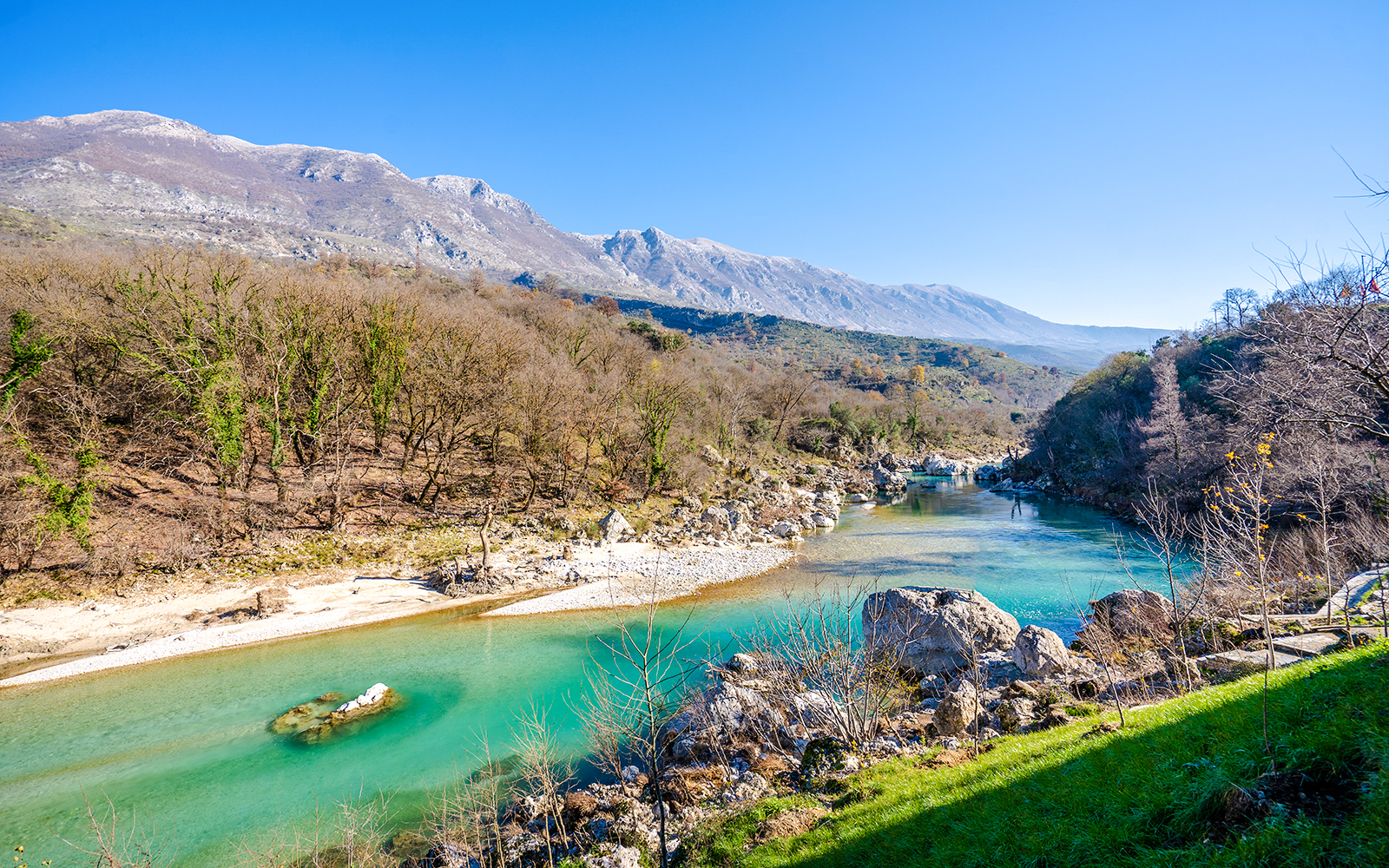Vjosa River flowing through a mountainous landscape in Albania.