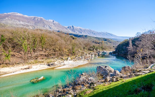 Vjosa River flowing through a mountainous landscape in Albania.