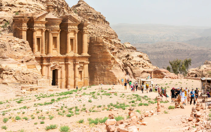 A-Dir Monastery in Petra, Jordan with tourists exploring the ancient site.