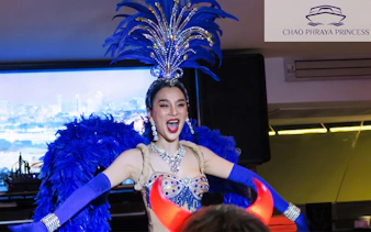 Performer in vibrant costume entertaining guests on Chao Phraya Princess New Year's Eve Dinner Cruise.
