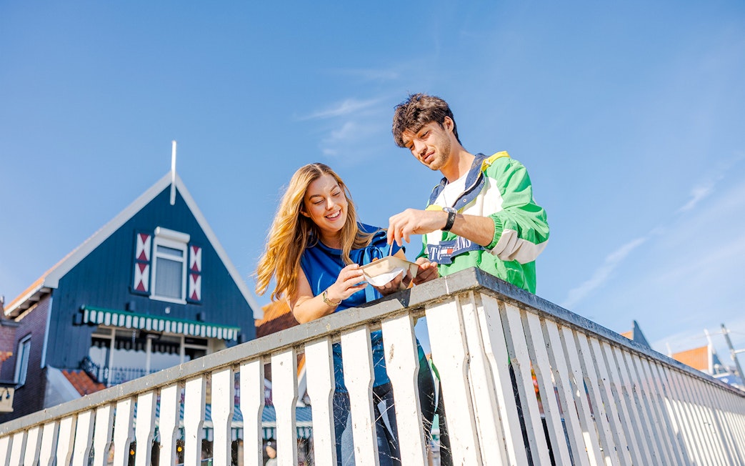 Guests enjoying snacks on a bridge in Volendam during the Zaanse Schans Tour.